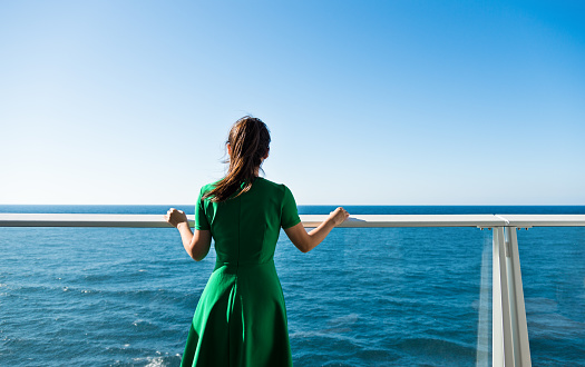 Asian woman standing near railings on cruise