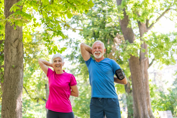 istock Mature Couple is Doing Warm-up Exercise in Public Park 1192314787