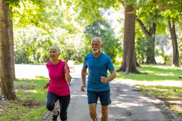 istock Active Senior Couple is Jogging Outdoors in Nature 1192314961
