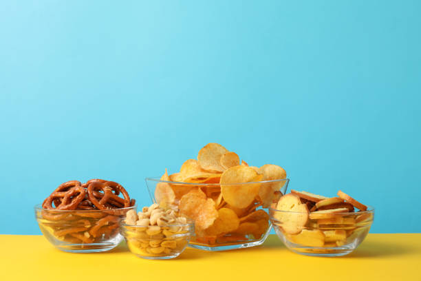 istock Beer snacks, potato chips, crackers in a bowl on yellow background against blue background, space for text 1192315186