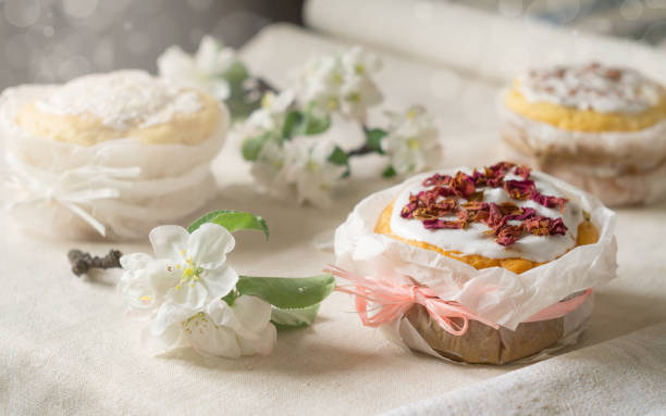istock Easter holiday. Traditional Easter cakes and blossoming apple tree branches on a linen tablecloth 1192315846