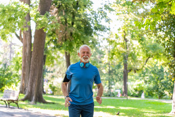 istock Handsome Mature Man is Jogging Outdoors in Nature 1192315904