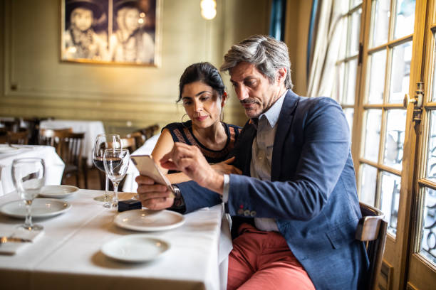 istock Mature couple suing smart phone in restaurant 1192316396