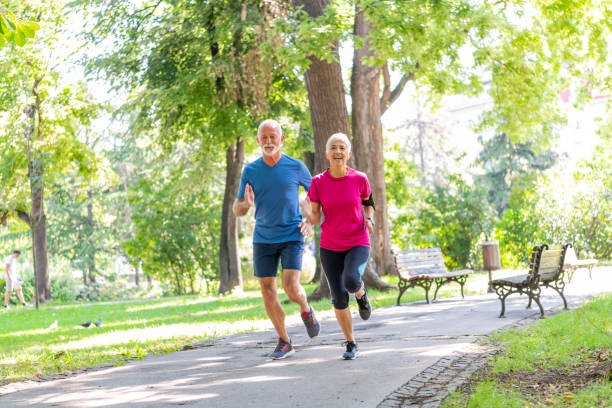 istock Active Senior Couple is Jogging Outdoors in Nature 1192316686