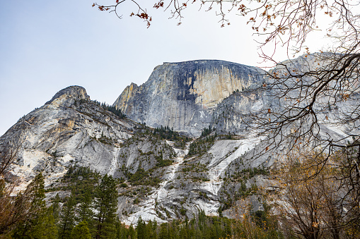 View of Hald Dome through fall trees shot in Yosemite Valley in the California Sierra Nevada Mountain range.