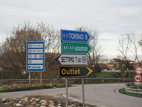 Various traffic signs including Torino (translation: Turin), Autostradale A4 A5 (translation: A4 A5 Motorway), Settimo, Outlet, No autostop