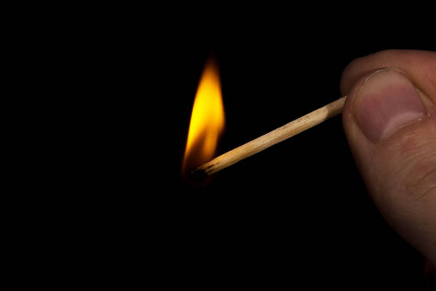 istock flame of a burning match rushing toward the fingers that held 1192327738