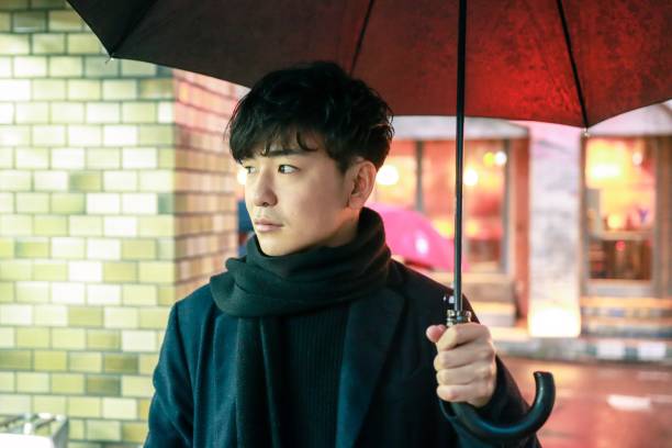 retrato de joven asiático bajo la lluvia en la ciudad de la noche - parasol umbrella asian ethnicity asian culture fotografías e imágenes de stock