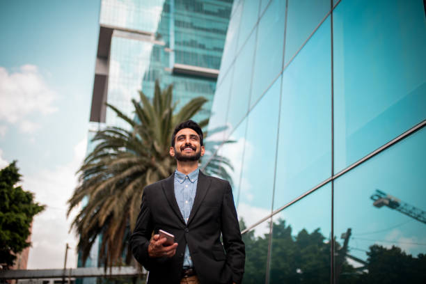 istock Young businessman using a mobile phone while walking down the street 1192333710