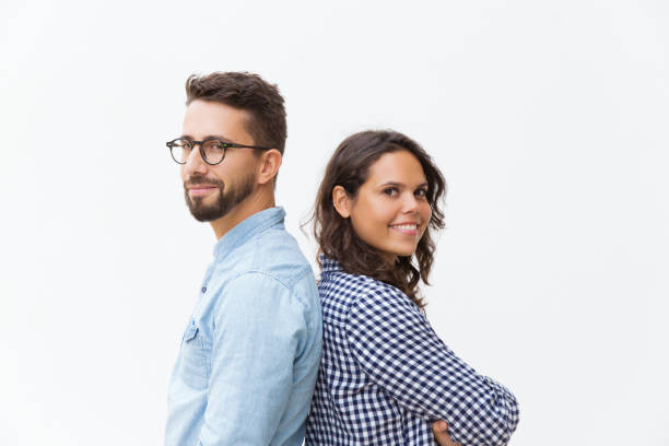istock Happy positive couple standing back-to-back, looking at camera 1192339193