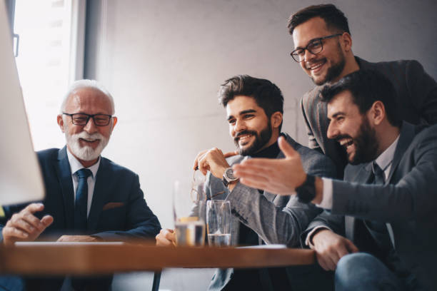istock Four cheerful businessmen looking at computer. 1192341387