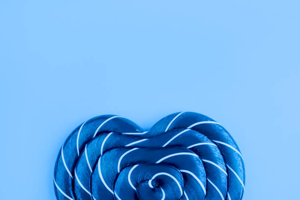 леденец на синем фоне. квартира лежала. минимальная концепция. - flavored ice lollipop candy affectionate стоковые фото и изображения
