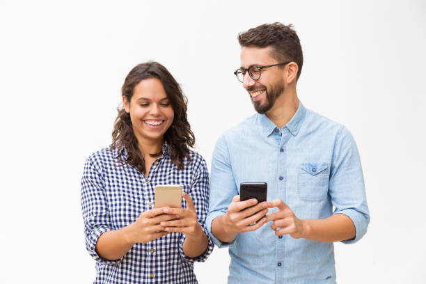 istock Joyful couple using smartphones 1192343908