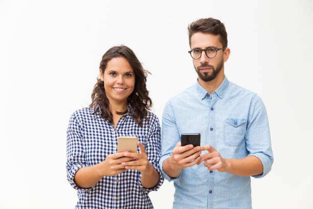 istock Couple standing close together and using smartphones 1192346696