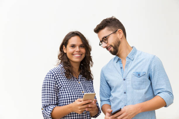 istock Smiling curious guy in glasses looking at girlfriend cellphone 1192348534