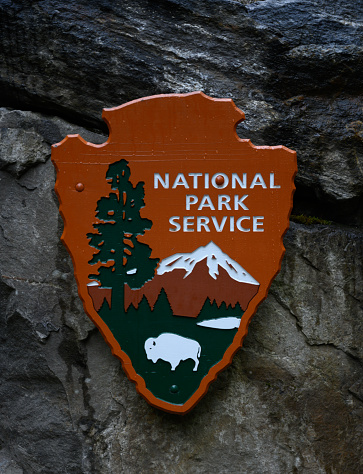 North Cascades National Park, United States: July 27, 2019: National Park Service Logo Hangs on Stone Wall