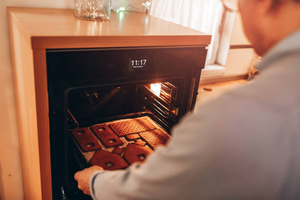 istock Senior Man Puts Christmas Gingerbread Cookies Into Oven 1192355793