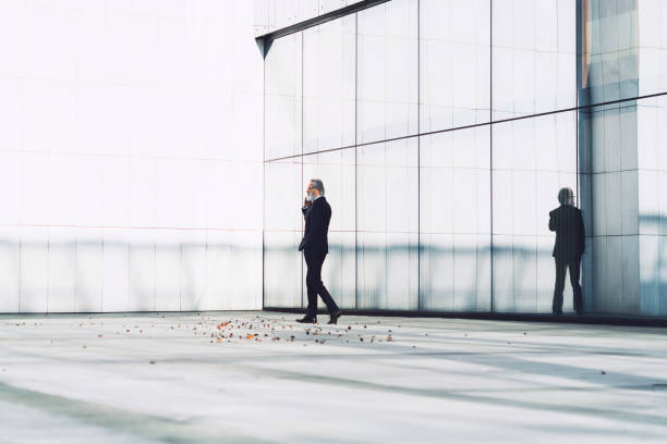 istock Businessman wearing a suit and tie making a phone call outside 1192359063