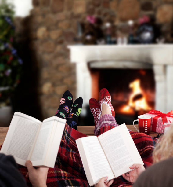 paar lesen buch zu hause, - blanket fireplace winter women stock-fotos und bilder