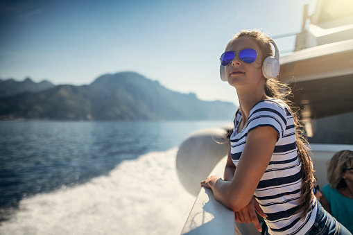 Adolescente viajando en barco cerca de la costa de Amalfi, Italia photo