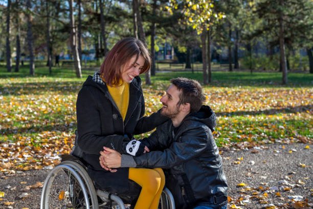Disabled girl with her boyfriend in the park stock photo