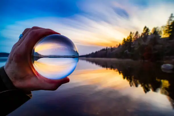 Glass ball with reflected sunset of a fantastic landscape during sunset
