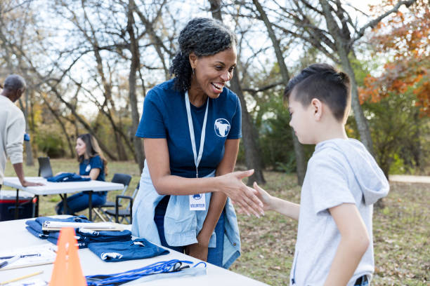 istock Female volunteer greets young boy 1192366454