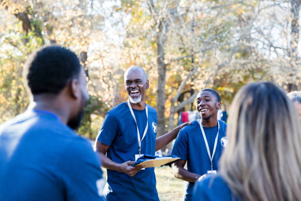 istock Happy mature volunteer coordinator talks with volunteers 1192366471