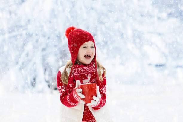 istock Child drinking chocolate on Christmas in snow 1192366580