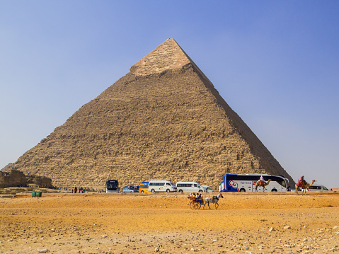 Cairo, Egypt - November 1, 2019: Tourist buses in front of the Pyramid of Khafre on the Giza necropolis.