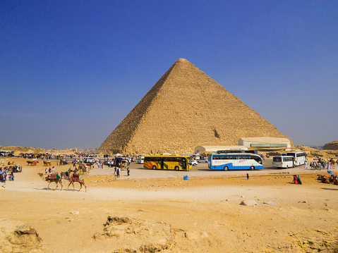 Cairo, Egypt - November 1, 2019: Tourist buses in front of the Pyramid of Khafre on the Giza necropolis.