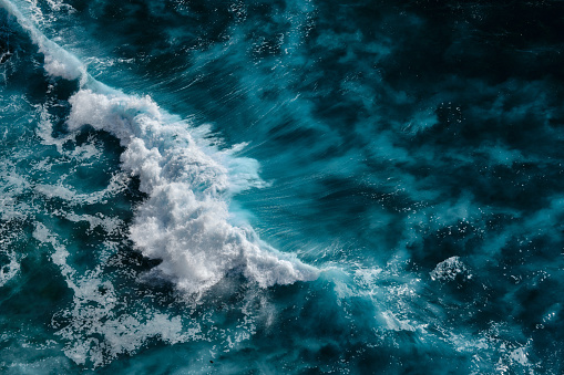 Aerial view to waves in ocean Splashing Waves. Blue clean wavy sea water. Bali, Indonesia.