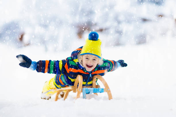 istock Boy on sled ride. Child sledding. Kid on sledge 1192367313