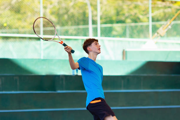 istock Young man playing tennis on open court 1192368499