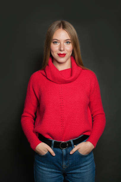 istock Cute young woman in red pullover on gray background 1192369344