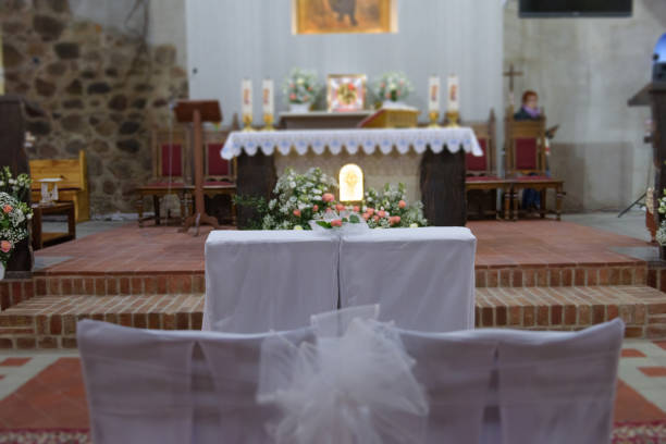 istock Church sanctuary before a wedding ceremony. Empty chairs for bride and groom. 1192369468