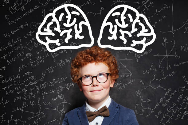 istock Little boy pupil in glasses with brain scetch on blackboard background 1192369517