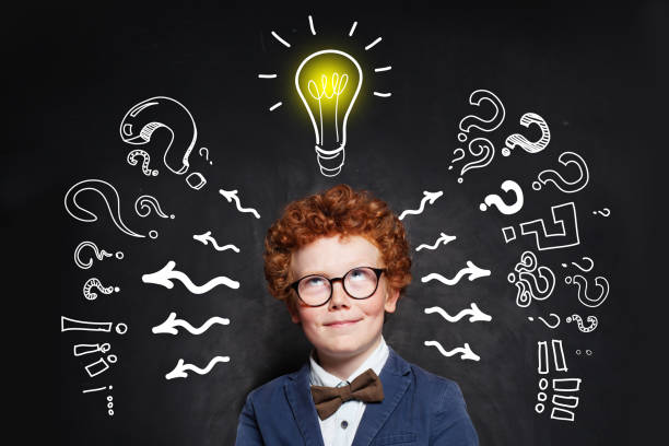 istock Cute school boy student with lightbulb on blackboard background 1192369525