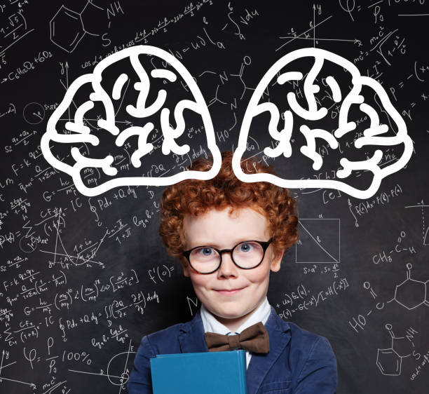 istock Young boy genius and brain power. Happy redhead kid against chalkboard 1192369531