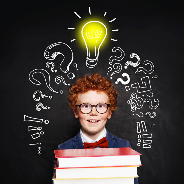 istock Redhead student child with lightbulb on blackboard background. Idea concept 1192369534