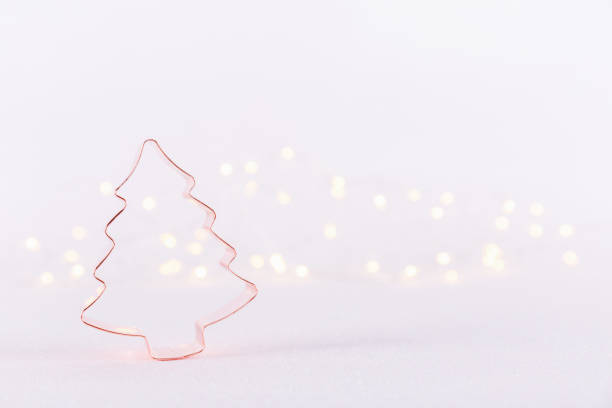 istock Christmas Tree Copper cookie cutter on white sparkling background with bokeh lights. Holiday Christmas and New Year background 1192373595