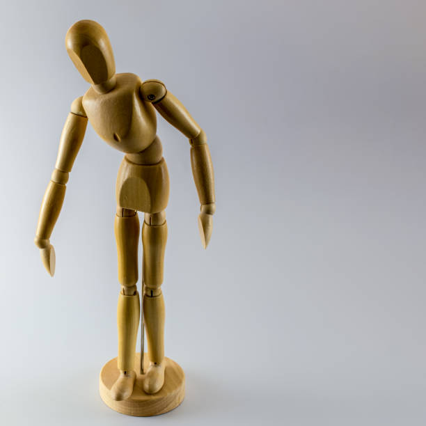 istock Wooden dummy mannequin looking down and taking a step, isolated. Copy space for text. 1192377311