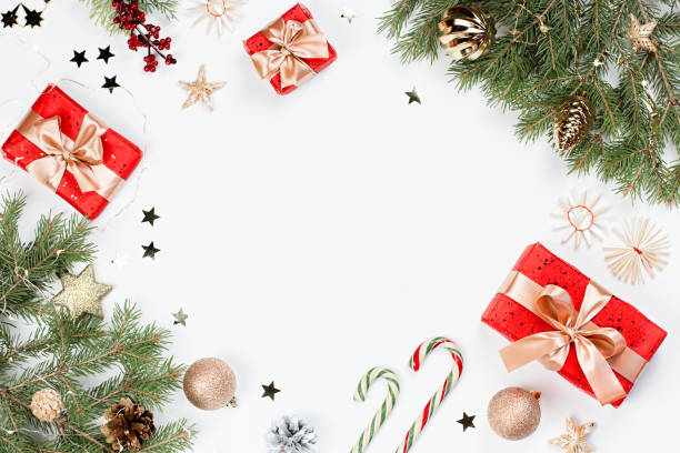 istock Christmas frame flat lay with pine, red presents, golden elements, candy canes, confetti. Christmas template on white background. Golden baubles, red gift boxes, pine. Christmas background, copy space 1192378852