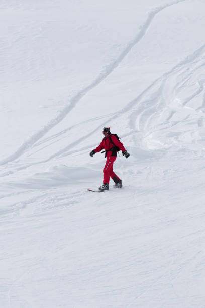 snowboarder declive na inclinação neveda fora de pista após a queda de neve - snowboarding snowboard teenager red - fotografias e filmes do acervo