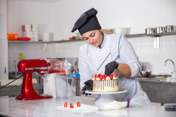 panadero hembra preparando pastel de edad de fresa - cake women confectioner photography fotografías e imágenes de stock