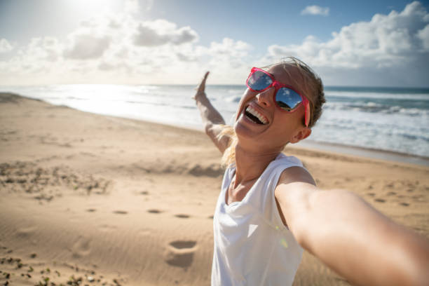istock Young woman taking selfie on beach 1192399652
