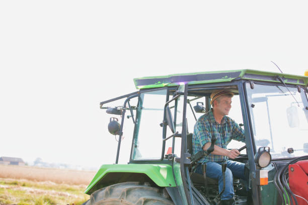 istock Mature farmer driving tractor in field 1192420101