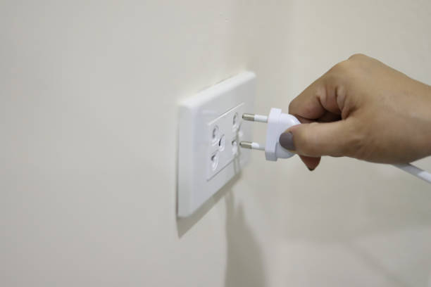 プラグを抜くか、プラグを差し込んで、電気プラグを引っ張る - electric plug outlet pulling electricity ストックフォトと画像