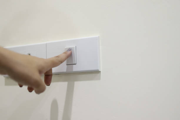istock Closeup hand turn off a power button. Hand pressing electronic-light switch. 1192423104