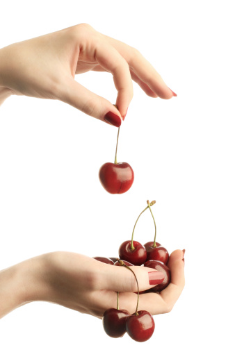 Two woman's hands with ripe cherries isolated on white background